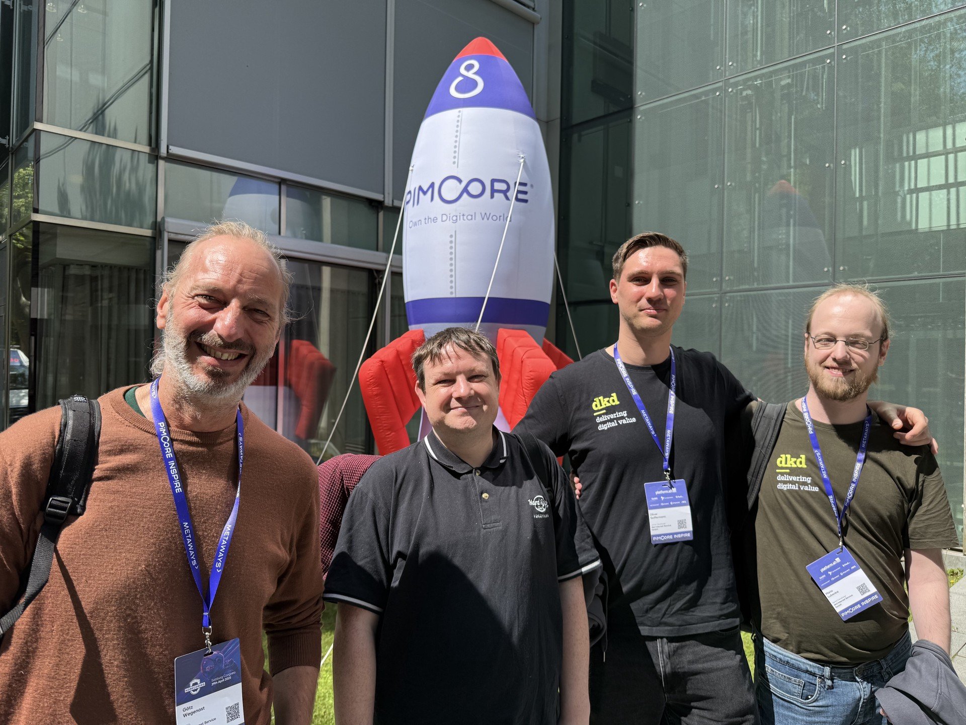 dkd-Team mit vier Entwicklern im Bild mit einer Pimcore-Rakete im Hintergrund