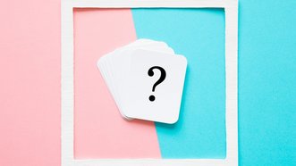 Die zehn häufigsten SEO-Fragen von Kunden Fragezeichen auf weissem Papier vor einem pink-blauem Hintergrund