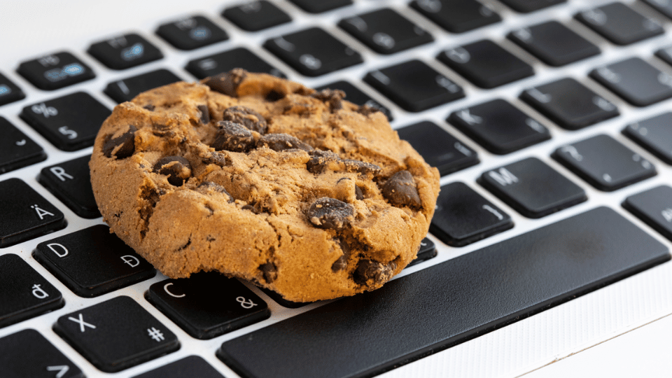 Cookie mit Schokostücken auf einer Mac-Tastatur